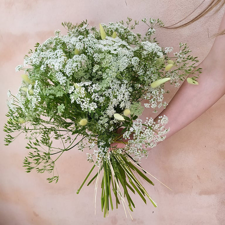 Høj, luftig buket med vilde blomster og græsser i hvide nuancer