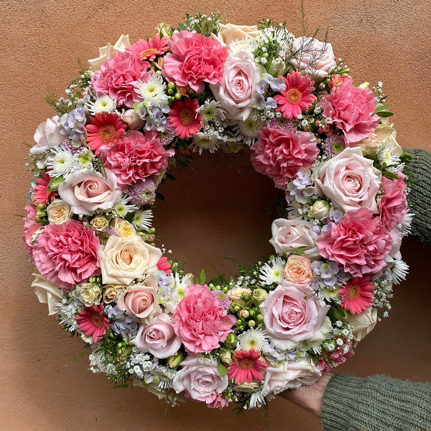 Rundpyntet krans i rosa nuancer