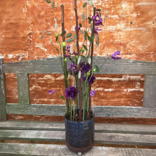 Dekoration med afskårne blomster i lilla nuancer