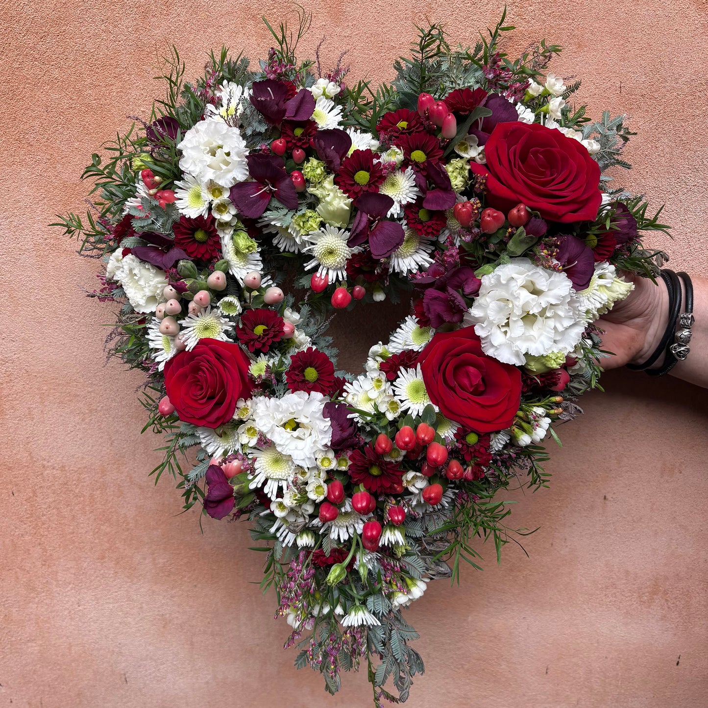 Åbent hjerte med afskårne blomster i røde og hvide nuancer