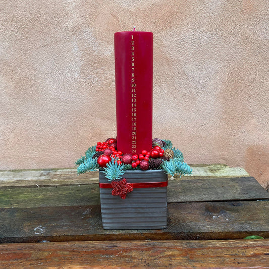 Juledekoration med kalenderlys i røde nuancer