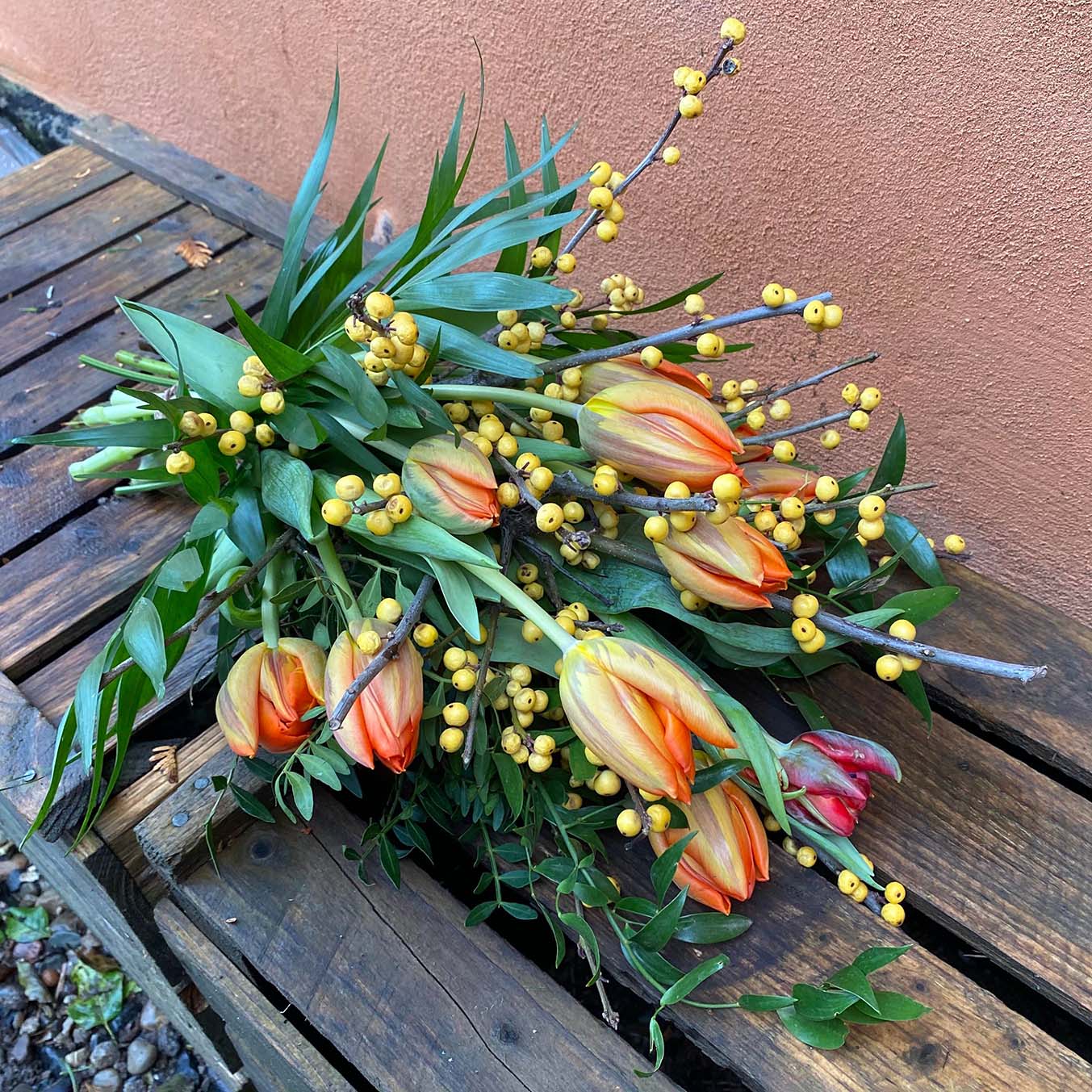 Bårebuket i orange nuancer med tulipaner. Begravelsesbinderi.
